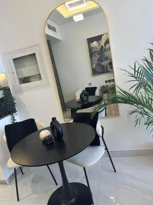 a table and chairs in a room with a mirror at Studio entièrement meublé in Dubai