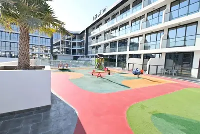 a large building with a colorful sidewalk in front of it at Studio entièrement meublé in Dubai