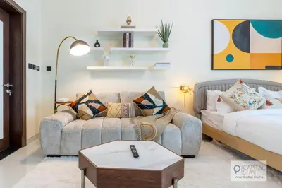 a living room with a couch and a bed at Capital Stay - Cozy Studio in Liwan Dubai in Dubai