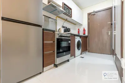 a laundry room with a washer and dryer at Capital Stay - Cozy Studio in Liwan Dubai in Dubai