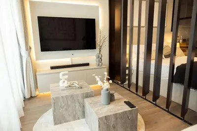 a living room with a television and a bed at WelHome - LOCI Residences in Dubai
