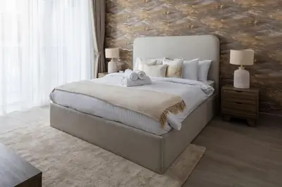 a bedroom with a large bed and a stone wall at Waves - Luxury Meets Comfort, Modern 1BR in JVCs Luma22 in Dubai