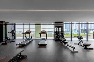 a gym with several treadmills in a room with windows at Old Form in Dubai