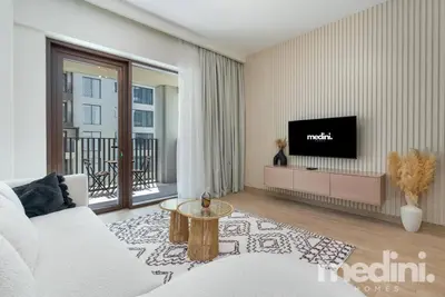 a living room with a white couch and a tv at 1-Bedroom - in Emaar Creek Harboor in Dubai