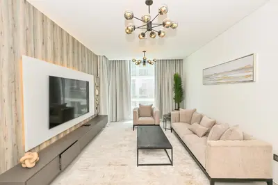 a living room with a couch and a tv at Centrally Located 1 Bedroom in District One Meydan in Dubai