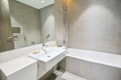 a bathroom with a sink and a bathtub and a sink at Family-friendly 1 Bedroom in District One Meydan in Dubai