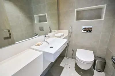 a white bathroom with a sink and a toilet at Family-friendly 1 Bedroom in District One Meydan in Dubai