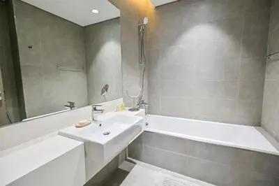 a bathroom with a sink and a bathtub and a sink at Modern 1BR in District One Meydan in Dubai
