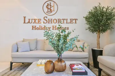 a living room with a couch and a table at 1BR w Exclusive Lagoon Access in District One Meydan in Dubai