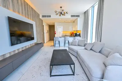 a living room with a couch and a flat screen tv at 1 Bedroom in District One Meydan in Dubai