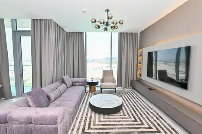 a living room with a couch and a tv at Magnificent 2BR in District One Meydan in Dubai