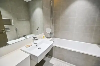a bathroom with a sink and a bathtub and a sink at 1BR Escape by the Lagoon in District One Meydan in Dubai