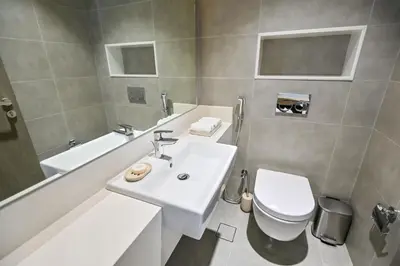a bathroom with a sink and a toilet and a tub at 1BR Escape by the Lagoon in District One Meydan in Dubai