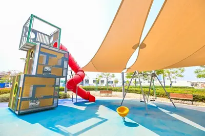 a playground with a slide and a swing set at 1BR Escape by the Lagoon in District One Meydan in Dubai