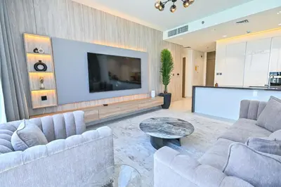 a living room with two couches and a large screen tv at Premium 2 Bedroom in District One Meydan in Dubai