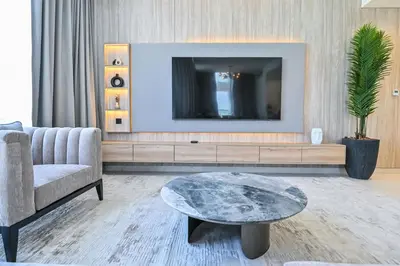 a living room with a tv and a couch and a table at Premium 2 Bedroom in District One Meydan in Dubai
