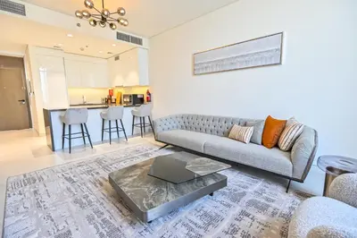 a living room with a couch and a table at 1BR Haven with Lagoon Serenity in District One Meydan in Dubai