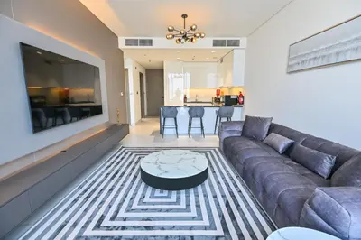a living room with a couch and a table at Spacious 1BR with Burj Khalifa View in District One Meydan in Dubai