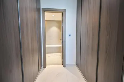 a hallway with wooden doors and a walk in closet at Spacious 1BR with Burj Khalifa View in District One Meydan in Dubai