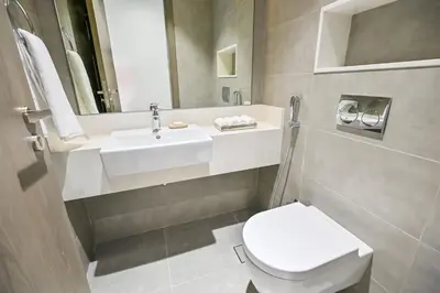 a bathroom with a white toilet and a sink at Unique 1BR in District One Meydan in Dubai