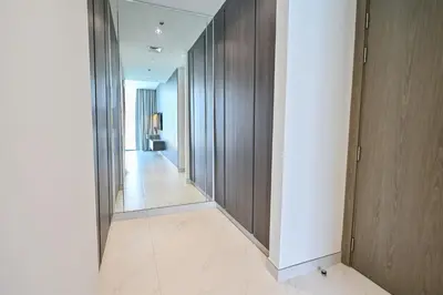 a hallway with wooden walls and a white tile floor at Unique 2 Bedroom in District One Meydan in Dubai
