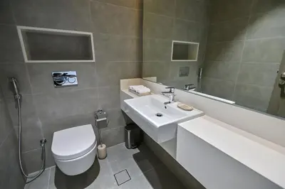 a bathroom with a white toilet and a sink at Unique 2 Bedroom in District One Meydan in Dubai