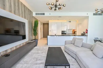 a living room with a couch and a tv at Unique 2 Bedroom in District One Meydan in Dubai