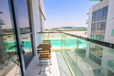 a balcony with chairs and a view of a swimming pool at 1BR Retreat by the Crystal Lagoon in District One Meydan in Dubai