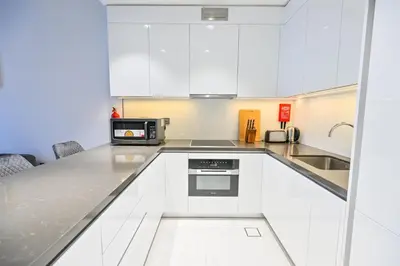 a kitchen with white cabinets and a microwave at 1BR with Lagoon Views in District One Meydan in Dubai
