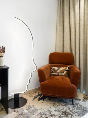 a living room with a chair and a lamp at Luxury Apartments at Paramount Midtown by Dale Lee in Dubai