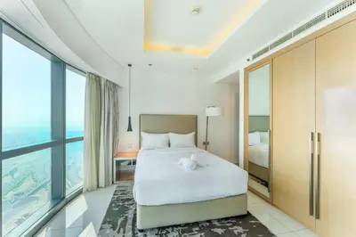 a bedroom with a bed and large windows at 3 Bed in DAMAC Paramount by PK Holidays in Dubai