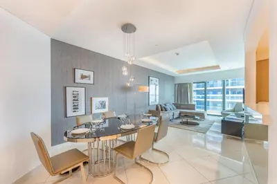 a dining room and living room with a table and chairs at 3 Bed in DAMAC Paramount by PK Holidays in Dubai