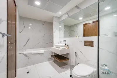 a white bathroom with a sink and a toilet at Spectacular 4BR Penthouse with Assistant Room in Hameni Tower, JVC by Deluxe Holiday Homes in Dubai