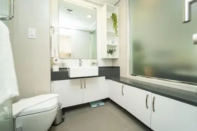 a white bathroom with a sink and a toilet at AWS Holiday Homes - Stylish Gem in the Palm in Dubai