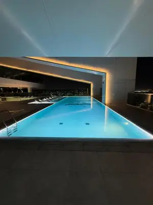 a large blue swimming pool in a building at Luxury 2BR Close to Sheikh Zayed Rd, Prime Location, Burj View Opposite Metro in Dubai