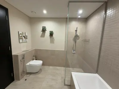 a bathroom with a toilet and a glass shower at Luxury 2BR Close to Sheikh Zayed Rd, Prime Location, Burj View Opposite Metro in Dubai