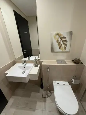a bathroom with a toilet and a sink and a mirror at Luxury 2BR Close to Sheikh Zayed Rd, Prime Location, Burj View Opposite Metro in Dubai