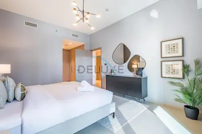 a bedroom with a large white bed and a mirror at Splendid 2BR Apartment at Act One Act Two Tower 2 in Downtown Dubai by Deluxe Holiday Homes in Dubai
