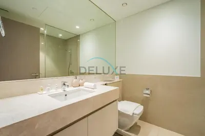 a bathroom with a sink and a toilet and a mirror at Splendid 2BR Apartment at Act One Act Two Tower 2 in Downtown Dubai by Deluxe Holiday Homes in Dubai