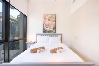 a bedroom with a bed with two pillows on it at Gorgeous 3BR Townhouse with Private Garden in Dubai