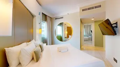 a bedroom with a large white bed and a mirror at The Signature - Two Bedroom in Downtown Dubai in Dubai