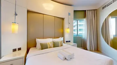 a bedroom with a large white bed with two towels on it at The Signature - Two Bedroom in Downtown Dubai in Dubai
