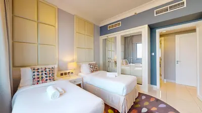 a hotel room with two beds and a bathroom at The Signature - Two Bedroom in Downtown Dubai in Dubai