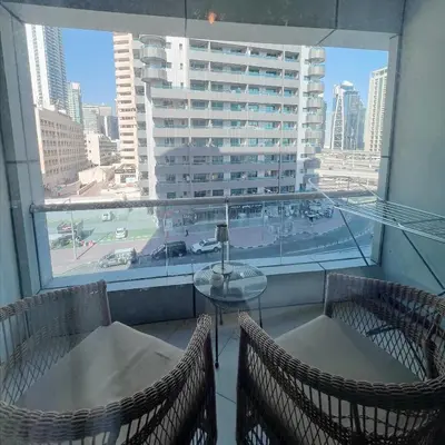 a balcony with two chairs and a table and a window at Fully Furnished Marina View - 1 Bedroom Apartment in Dubai