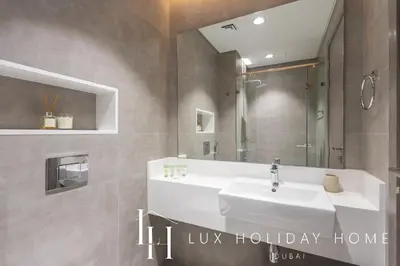 a bathroom with a white sink and a mirror at LUX 2BR Lagoon View District One, 10 to 15 min Burj Khalifa in Dubai