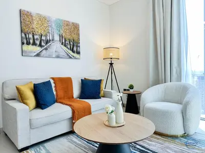 a living room with a couch and two chairs and a table at Stylish 2BR Escape 2 Balconies Pool View in Dubai