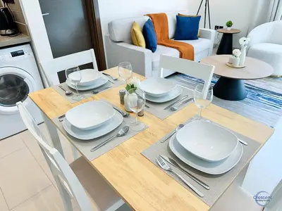 a dining room table with plates and wine glasses at Stylish 2BR Escape 2 Balconies Pool View in Dubai