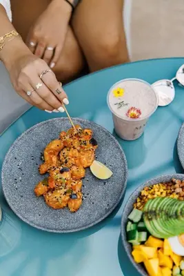 a person eating food on a table with a plate of food at Frank Porter - Damac Prive A in Dubai