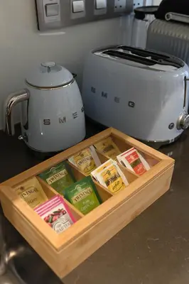 a wooden tray with packets of food next to a toaster at 610 lagoon views in Dubai