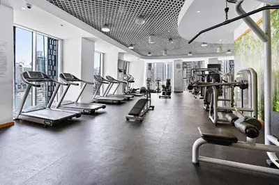 a gym with rows of treadmills and machines at Stayis -Studio in Twisted Tower Dubai Marina in Dubai